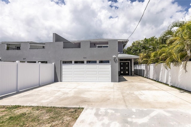 839 Oneawa St, Kailua, HI 96734 - view of front of house featuring an attached garage, stucco siding, and concrete driveway