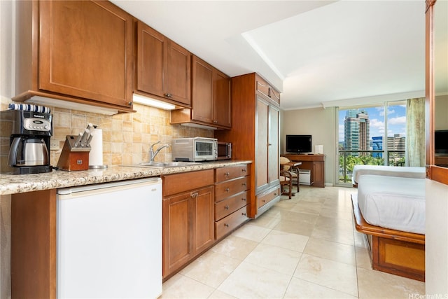 2045 Kalakaua Ave Unit 604, Honolulu, HI 96815 - kitchen featuring refrigerator, decorative backsplash, brown cabinetry, and a sink
