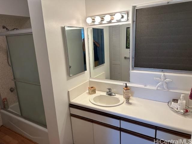 full bath with vanity and combined bath / shower with glass door