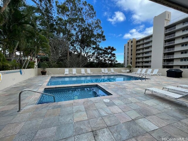 community pool with a patio, area for grilling, and a community hot tub
