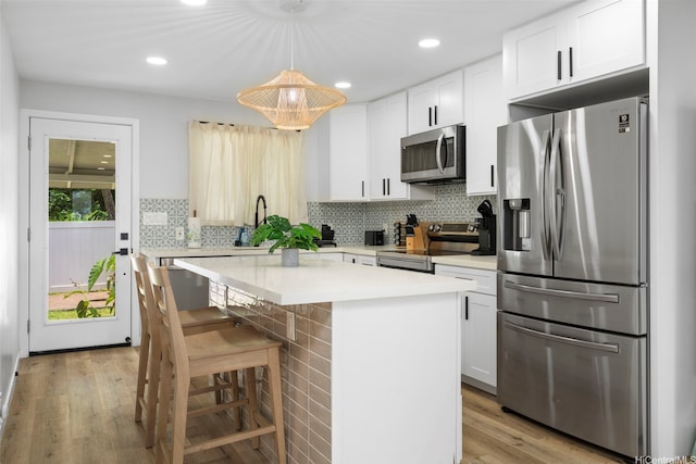 54-100 Kamehameha Hwy, Hauula, HI 96717 - kitchen featuring appliances with stainless steel finishes, a kitchen island, light wood-type flooring, light countertops, and white cabinetry