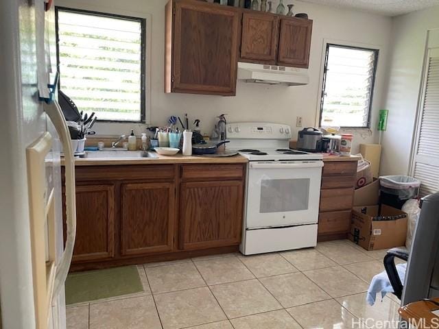47-166 Wailehua Rd, Kaneohe, HI 96744 - kitchen featuring white appliances, under cabinet range hood, light tile patterned flooring, and plenty of natural light