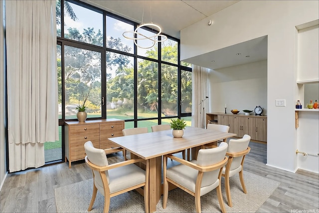 5333 Likini St Unit 110, Honolulu, HI 96818 - dining area with healthy amount of natural light, light wood-style flooring, expansive windows, and a high ceiling