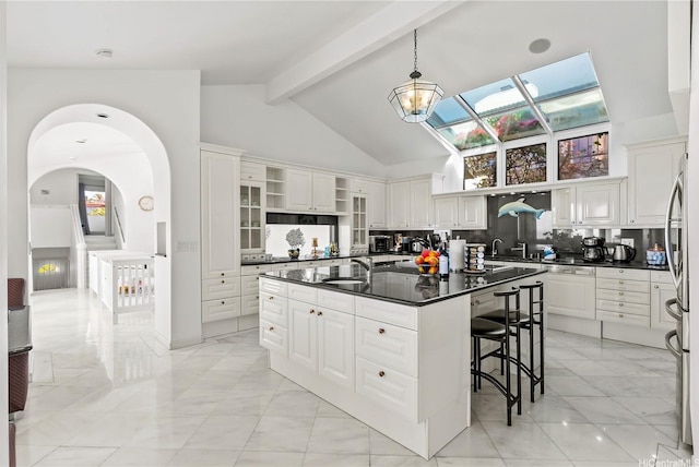 671 Kahiau Loop, Honolulu, HI 96821 - kitchen featuring light marble finish floors, dark countertops, a kitchen bar, open shelves, and white cabinets