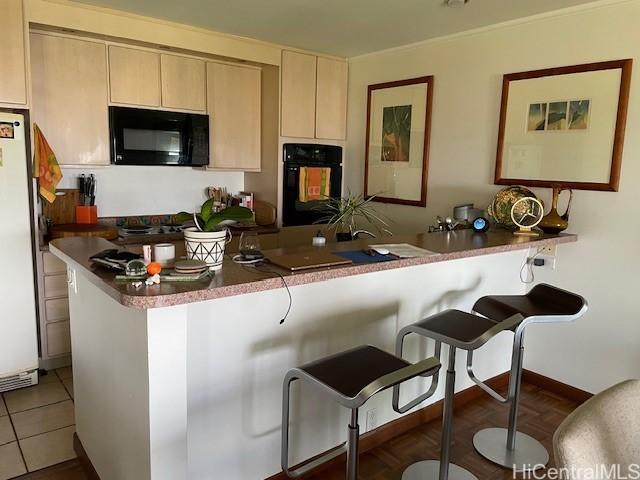 389 Kaelepulu Dr Unit 1501, Kailua, HI 96734 - kitchen with black appliances, a breakfast bar area, and tile patterned flooring