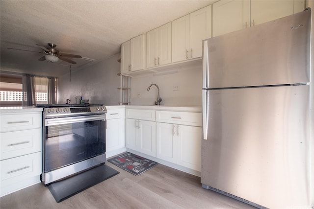 98-080 Uao Pl Unit C9, Aiea, HI 96701 - kitchen featuring appliances with stainless steel finishes, light wood finished floors, white cabinets, a textured ceiling, and light countertops