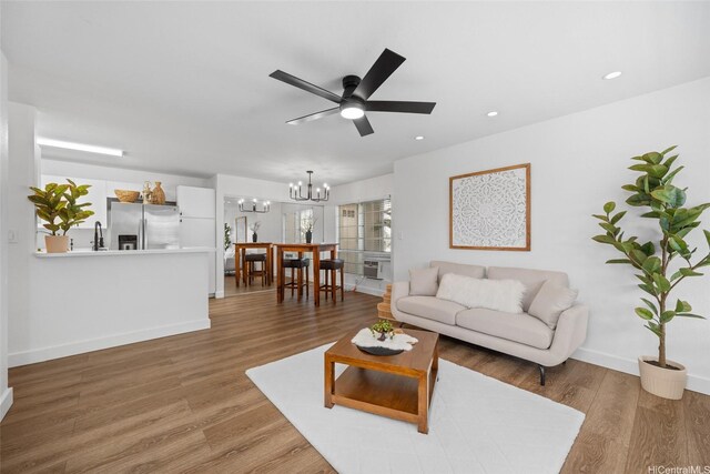 306 Mananai Pl Unit 4D, Honolulu, HI 96818 - living room featuring a chandelier, ceiling fan, baseboards, recessed lighting, and light wood-type flooring