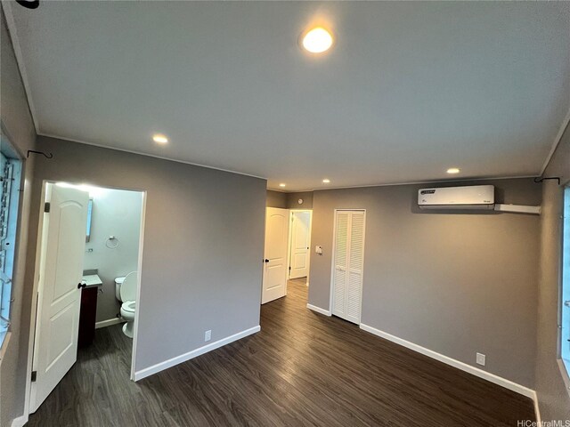 612 Ainapo St, Honolulu, HI 96825 - unfurnished bedroom featuring an AC wall unit, dark wood-type flooring, baseboards, recessed lighting, and ensuite bath