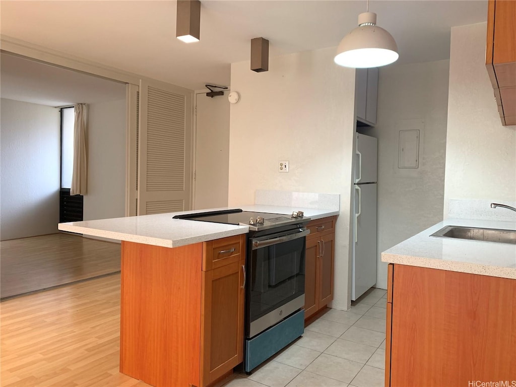 320 Liliuokalani Ave Unit 605, Honolulu, HI 96815 - kitchen featuring stainless steel range with electric stovetop, freestanding refrigerator, a sink, and light countertops