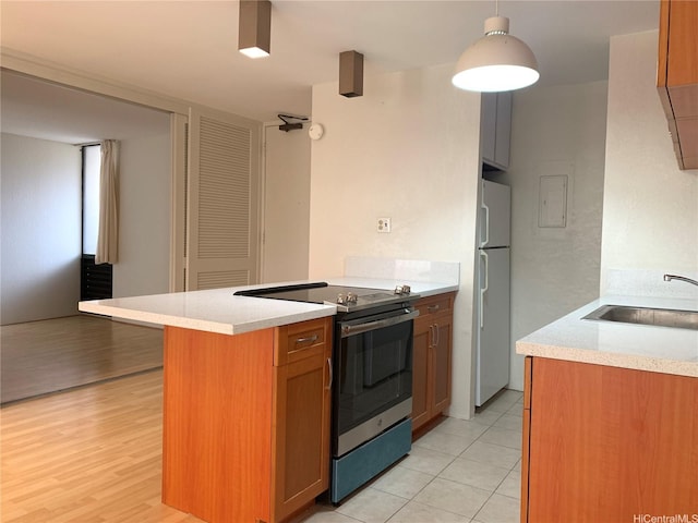 320 Liliuokalani Ave Unit 605, Honolulu, HI 96815 - kitchen featuring stainless steel range with electric stovetop, freestanding refrigerator, a sink, and light countertops