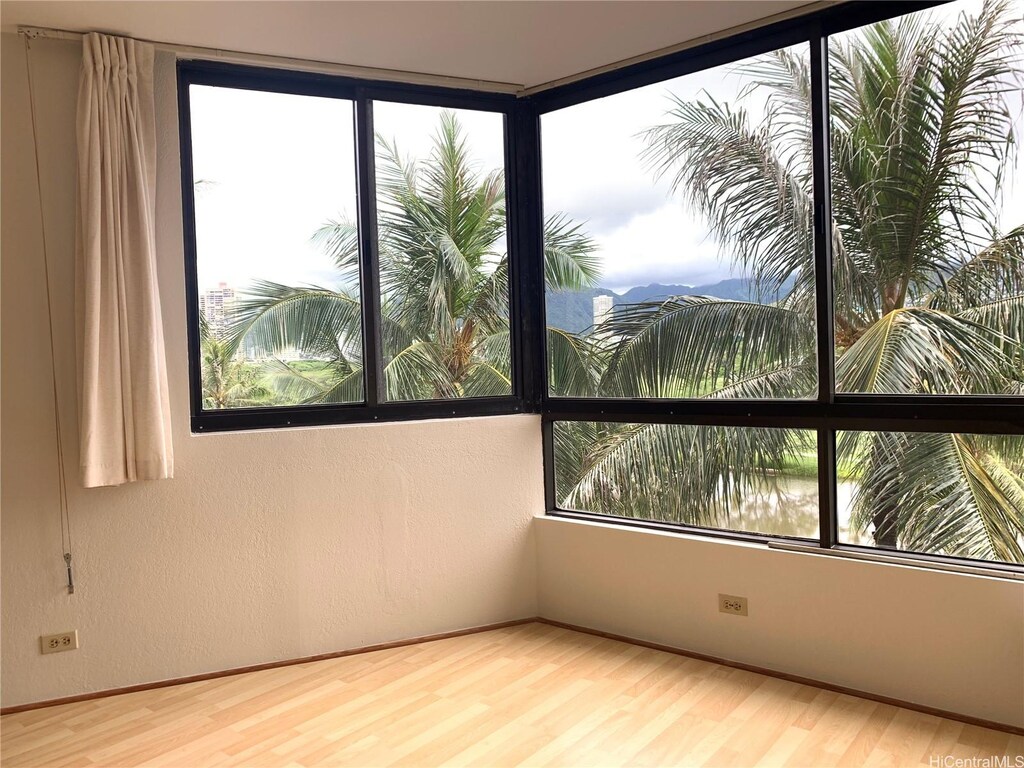 320 Liliuokalani Ave Unit 605, Honolulu, HI 96815 - spare room with wood finished floors, healthy amount of natural light, and baseboards