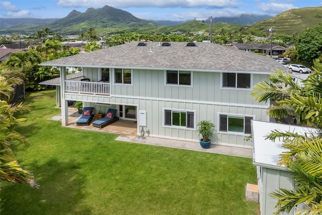 440 Akoakoa Pl, Kailua, HI 96734 - rear view of property with board and batten siding, roof with shingles, a patio area, a mountain view, and a yard