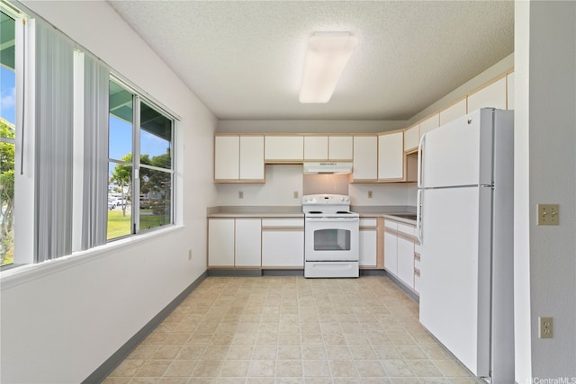 95-1180 Makaikai St Unit 74, Mililani, HI 96789 - kitchen with white appliances, under cabinet range hood, light countertops, a textured ceiling, and baseboards