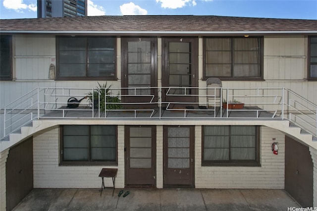 2459 Kapiolani Blvd, Honolulu, HI 96826 - back of house featuring stairs, brick siding, and roof with shingles