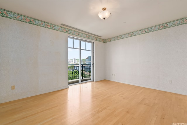 1740 S Beretania St Unit 10, Honolulu, HI 96826 - spare room with wood finished floors, baseboards, and wallpapered walls