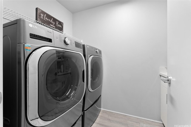91-1669 Mee St, Ewa Beach, HI 96706 - laundry room with washing machine and dryer, light wood-style flooring, and baseboards