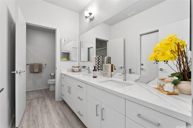 91-1669 Mee St, Ewa Beach, HI 96706 - bathroom featuring double vanity, toilet, wood finished floors, and a shower with door