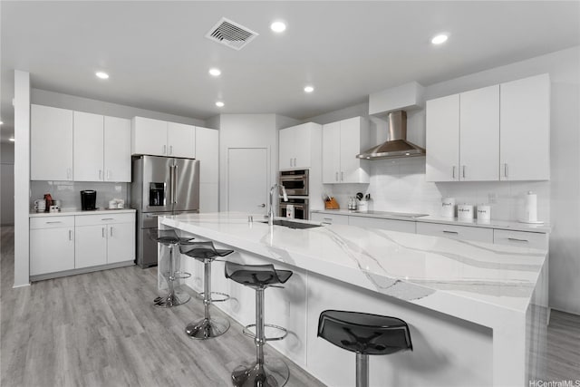 91-1669 Mee St, Ewa Beach, HI 96706 - kitchen featuring wall chimney range hood, stainless steel appliances, a sink, tasteful backsplash, and a breakfast bar area