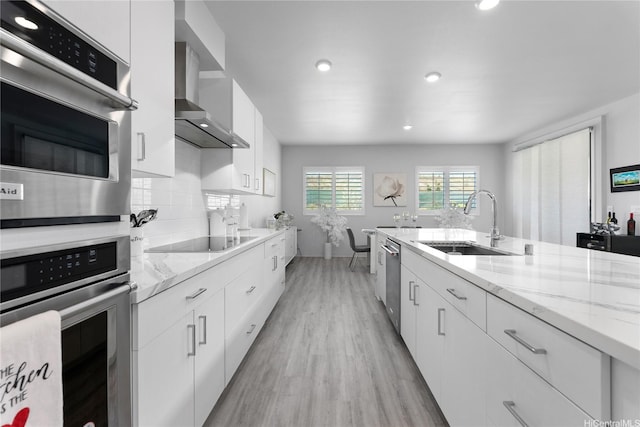 91-1669 Mee St, Ewa Beach, HI 96706 - kitchen with a sink, wall chimney exhaust hood, stainless steel appliances, light wood finished floors, and white cabinets