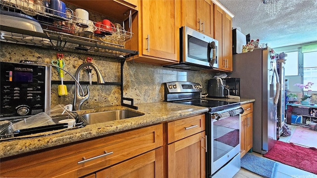 1550 Rycroft St Unit 323, Honolulu, HI 96814 - kitchen featuring stainless steel appliances, a sink, tasteful backsplash, light stone countertops, and brown cabinets