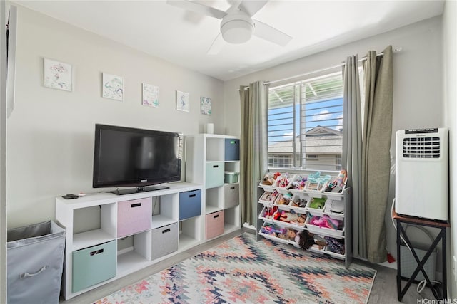 95-1031 Kuauli St Unit 87, Mililani, HI 96789 - playroom featuring wood finished floors, a ceiling fan, and heating unit