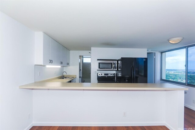 1060 Kamehameha Hwy Unit 2303A, Pearl City, HI 96782 - kitchen featuring appliances with stainless steel finishes, light countertops, a peninsula, and dark wood finished floors