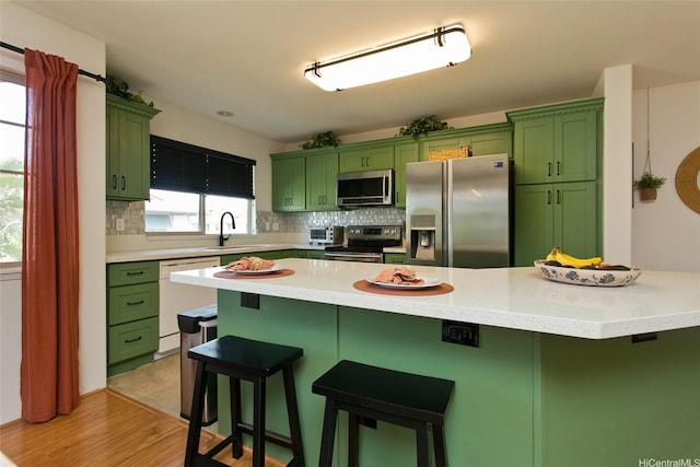 91-1175 Kaiau Ave Unit 903, Kapolei, HI 96707 - kitchen featuring green cabinets, stainless steel appliances, a sink, and a kitchen breakfast bar
