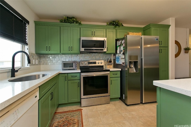 91-1175 Kaiau Ave Unit 903, Kapolei, HI 96707 - kitchen with appliances with stainless steel finishes, green cabinets, a sink, and backsplash
