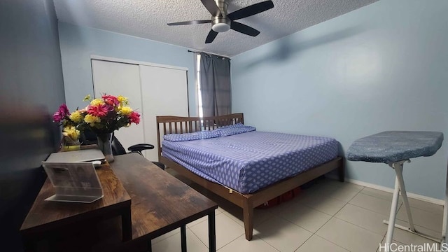 3161 Ala Ilima St Unit 2112, Honolulu, HI 96818 - bedroom featuring a textured ceiling, a closet, baseboards, light tile patterned flooring, and a ceiling fan
