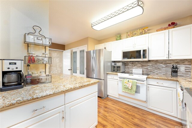 94-816 Lumiauau St Unit Kk102, Waipahu, HI 96797 - kitchen featuring appliances with stainless steel finishes, white cabinets, backsplash, light wood-style floors, and light stone counters