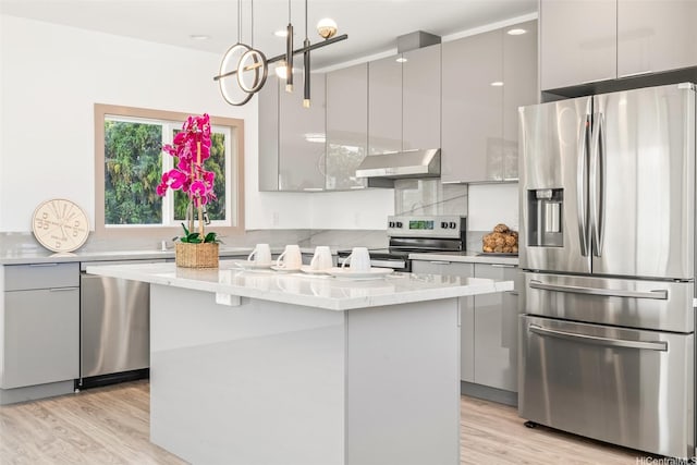 1528 Hooli Cir, Pearl City, HI 96782 - kitchen with appliances with stainless steel finishes, modern cabinets, under cabinet range hood, a kitchen island, and light wood finished floors
