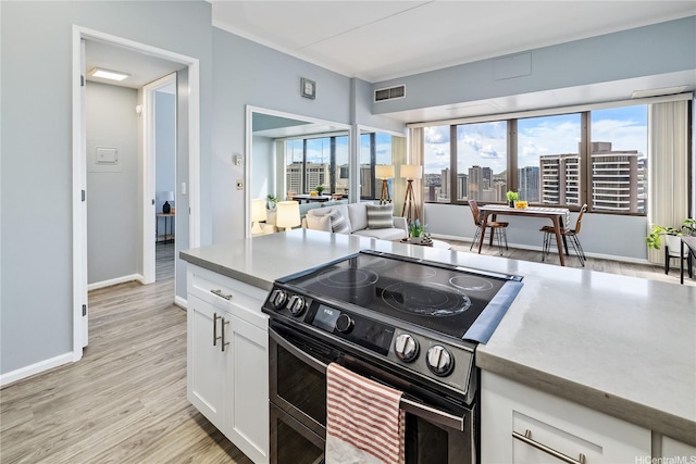 411 Hobron Ln Unit 3905, Honolulu, HI 96815 - kitchen featuring range with electric cooktop, white cabinets, light wood-style flooring, baseboards, and light countertops