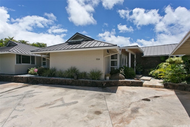 759 Elepaio St, Honolulu, HI 96816 - view of front of house featuring a standing seam roof, metal roof, brick siding, and a patio