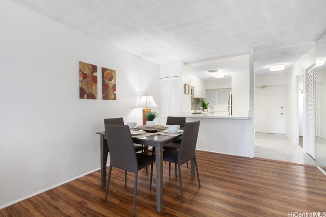 2488 Kapiolani Blvd Unit 203, Honolulu, HI 96826 - dining room featuring light wood-style floors and a textured ceiling