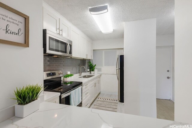 2488 Kapiolani Blvd Unit 203, Honolulu, HI 96826 - kitchen with appliances with stainless steel finishes, a sink, a textured ceiling, light countertops, and decorative backsplash