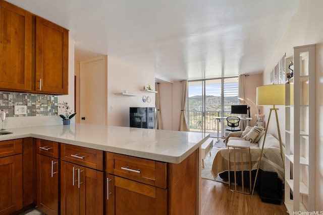 2452 Tusitala St Unit 1207, Honolulu, HI 96815 - kitchen featuring a peninsula, decorative backsplash, floor to ceiling windows, open floor plan, and brown cabinetry