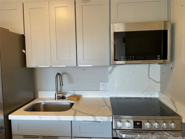 2888 Ala Ilima St Unit 910, Honolulu, HI 96818 - kitchen with appliances with stainless steel finishes, a sink, backsplash, and light stone countertops