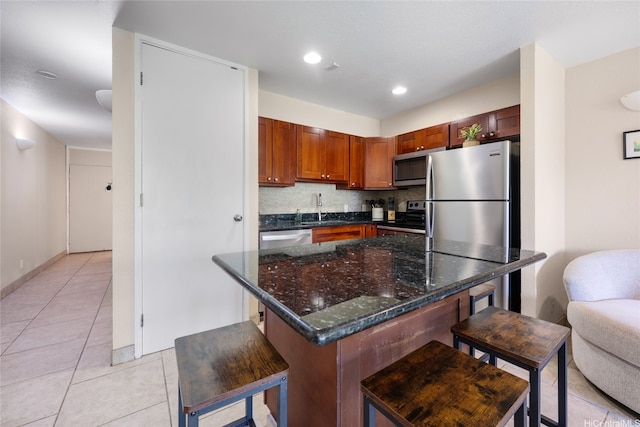 57-91 Lalo Kuilima Pl Unit 5/47, Kahuku, HI 96731 - kitchen featuring stainless steel appliances, a sink, a kitchen bar, tasteful backsplash, and light tile patterned floors