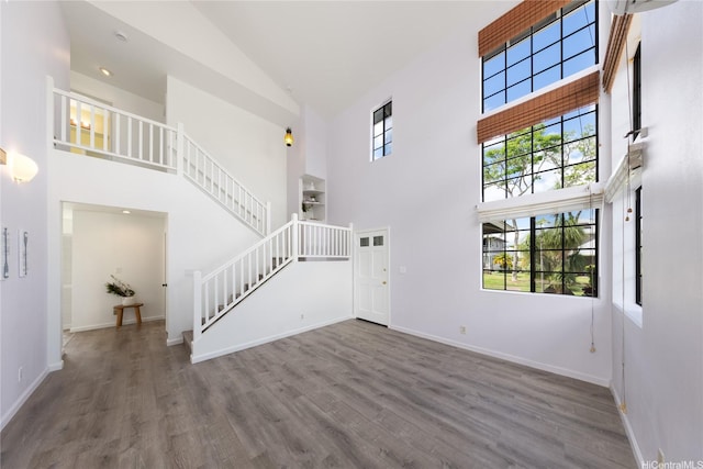 91-1011 Aeoia St Unit A, Ewa Beach, HI 96706 - unfurnished living room with high vaulted ceiling, wood finished floors, stairs, and baseboards