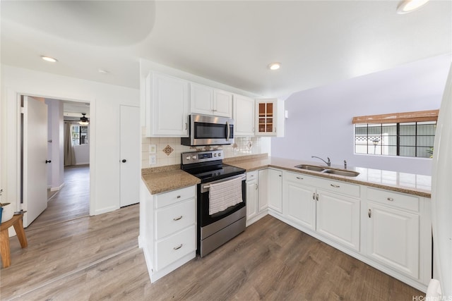 91-1011 Aeoia St Unit A, Ewa Beach, HI 96706 - kitchen with appliances with stainless steel finishes, a sink, light wood-style floors, white cabinetry, and recessed lighting