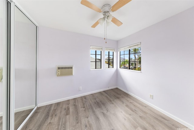 91-1011 Aeoia St Unit A, Ewa Beach, HI 96706 - unfurnished room with light wood-type flooring, an AC wall unit, baseboards, and a ceiling fan