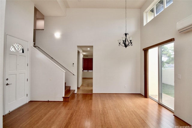91-1066 Lanakoi St, Kapolei, HI 96707 - entryway featuring a high ceiling, light wood-type flooring, a chandelier, stairway, and a wall mounted AC