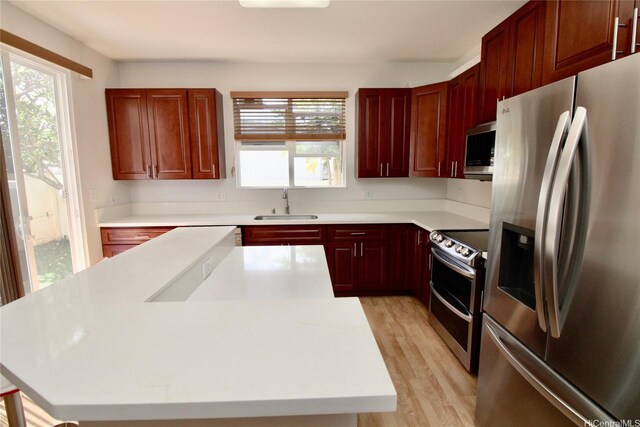 91-1066 Lanakoi St, Kapolei, HI 96707 - kitchen with stainless steel appliances, a sink, dark brown cabinets, light wood-style flooring, and a kitchen island