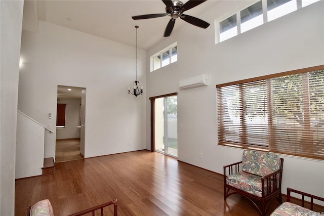 91-1066 Lanakoi St, Kapolei, HI 96707 - living area with an AC wall unit, wood finished floors, a high ceiling, ceiling fan, and a chandelier
