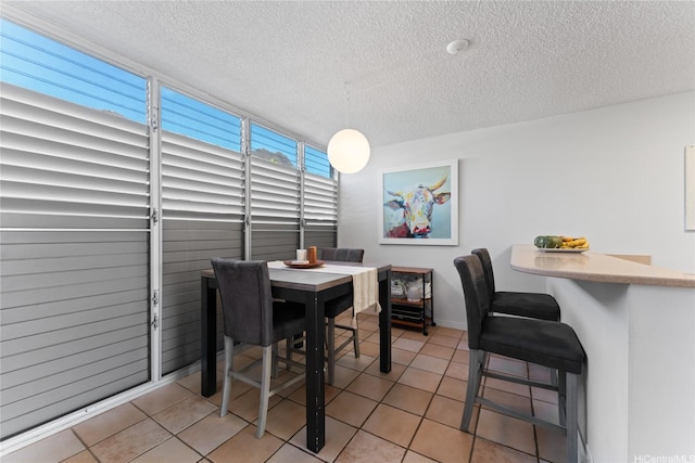 3030 Pualei Cir Unit 311, Honolulu, HI 96815 - dining area featuring a textured ceiling, light tile patterned floors, and baseboards