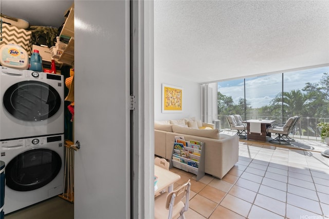 3030 Pualei Cir Unit 311, Honolulu, HI 96815 - laundry area with stacked washing machine and dryer, light tile patterned floors, and a textured ceiling