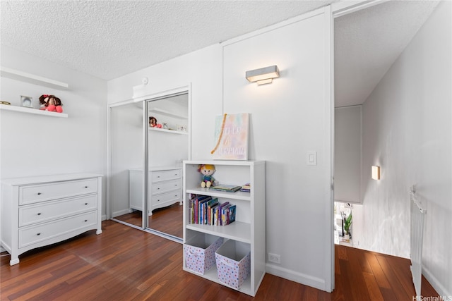 3030 Pualei Cir Unit 311, Honolulu, HI 96815 - bedroom featuring dark wood finished floors, baseboards, a textured ceiling, and a closet