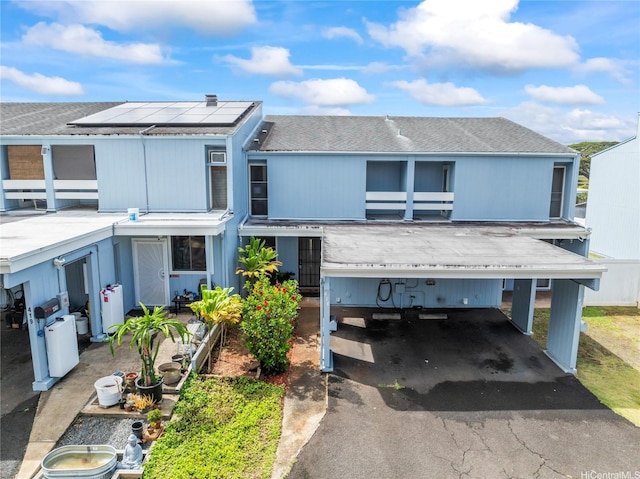 95-112 Kipapa Dr Unit 418, Mililani, HI 96789 - view of property with roof mounted solar panels, asphalt driveway, a carport, and roof with shingles