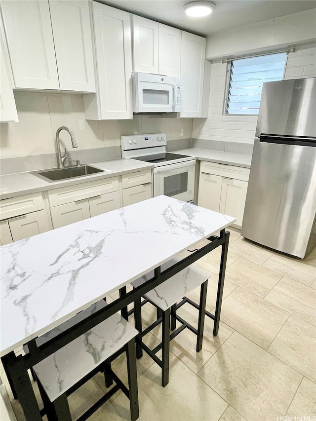 410 Nahua St Unit 106, Honolulu, HI 96815 - kitchen with white appliances, a sink, white cabinetry, and light stone counters
