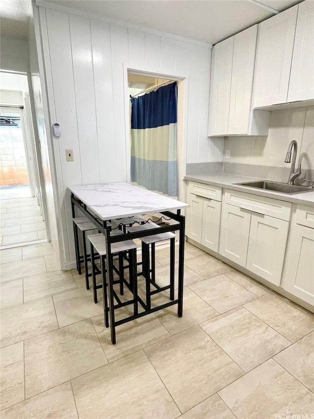410 Nahua St Unit 106, Honolulu, HI 96815 - kitchen with a sink, light countertops, white cabinetry, and light tile patterned floors